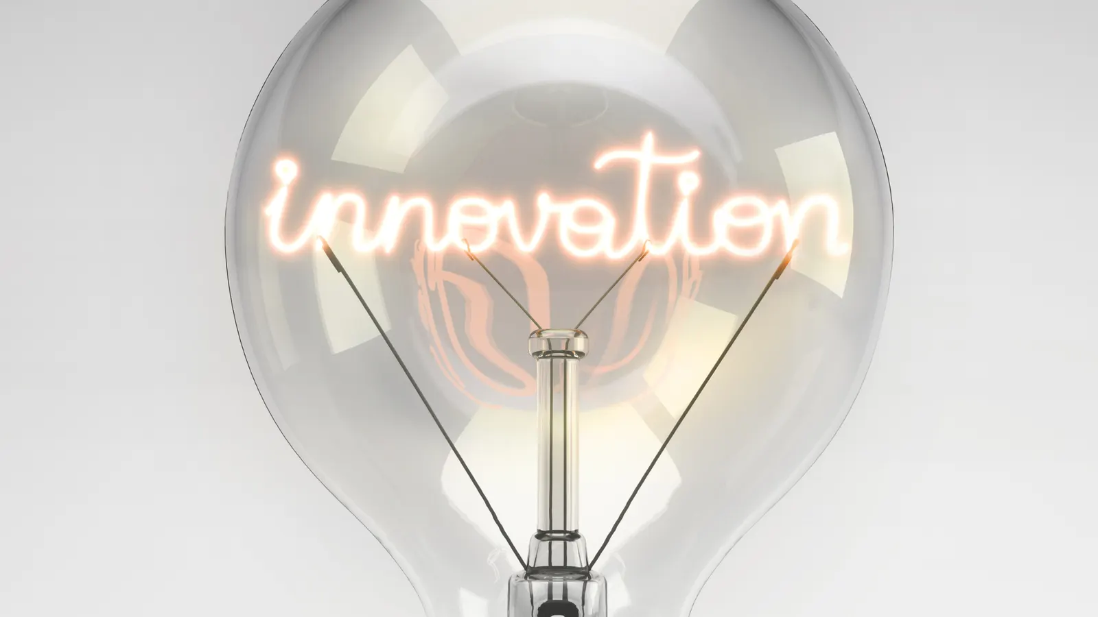A glass light bulb with a glowing filament spelling the word innovation.